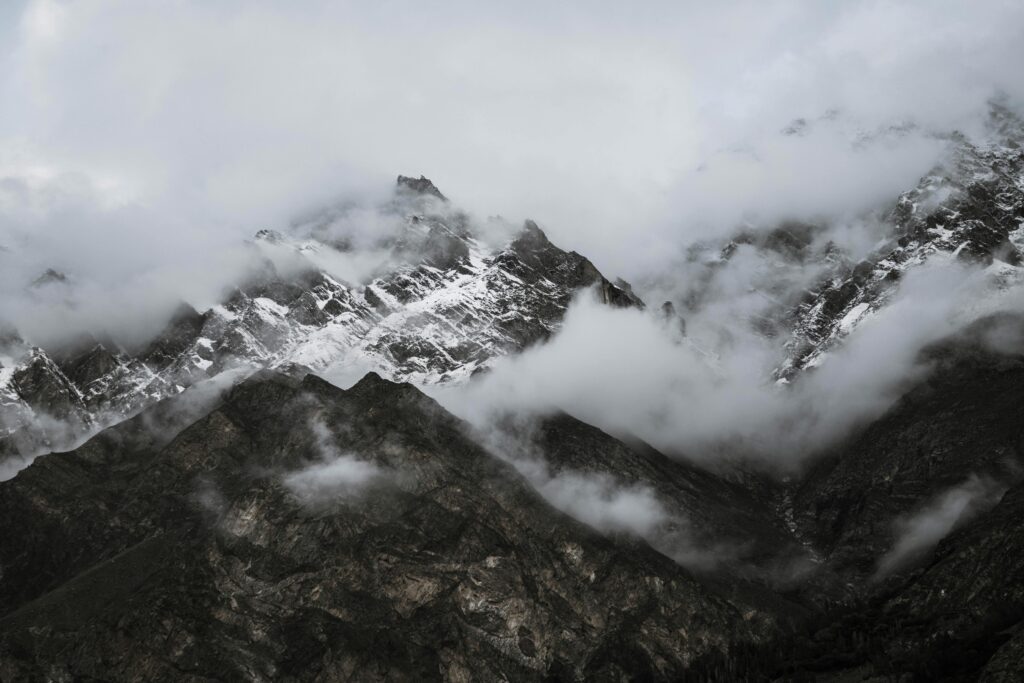 Capture of rugged snow-capped mountains shrouded in mist, creating a mysterious and tranquil landscape.
