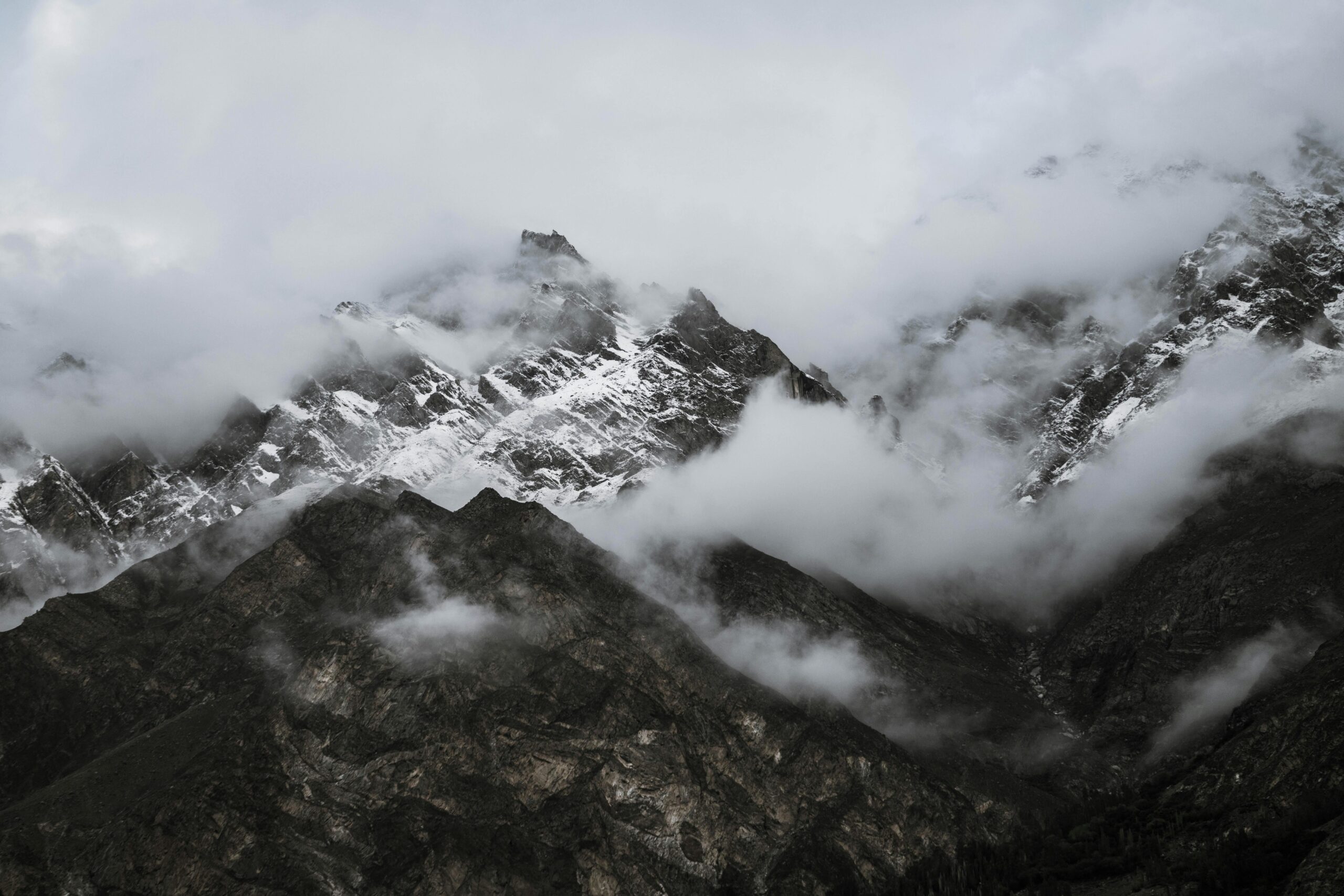 Capture of rugged snow-capped mountains shrouded in mist, creating a mysterious and tranquil landscape.